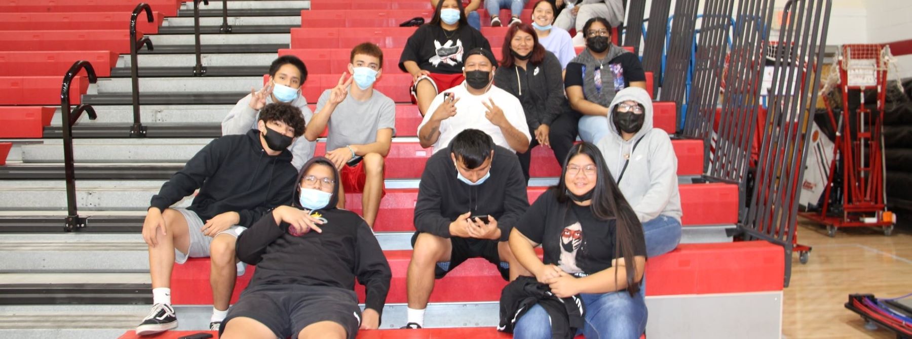 Students sitting on the bleachers in the gym.