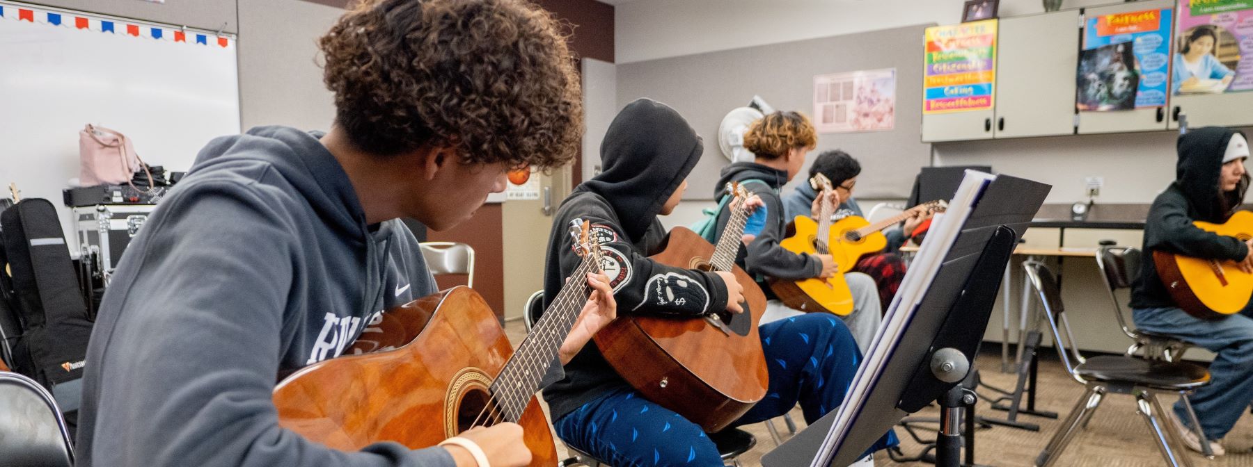 Students playing guitars in band room