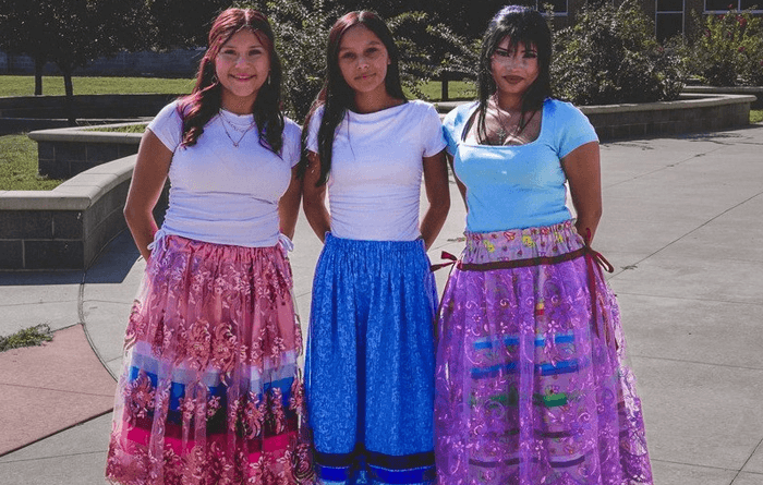 Three female students are wearing ribbon skirts