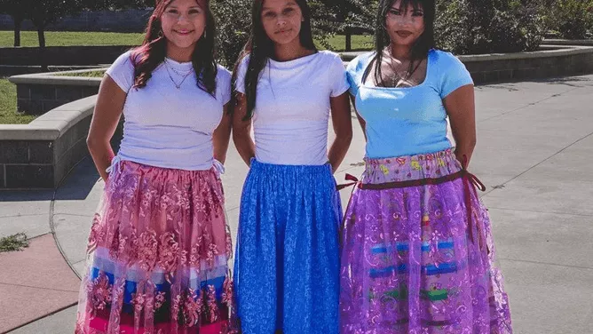  Three female students are wearing ribbon skirts